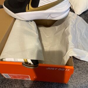 Nike Black and Metallic Gold Team Hustle Sneakers